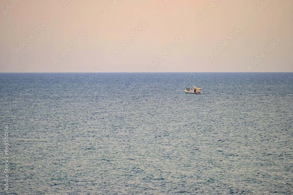 Fototapeta premium Small fishing boat sailing in an open Mediterranean sea, close-up.
