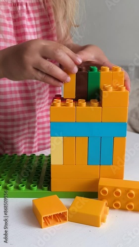 little girl plays color constructor sitting children room table