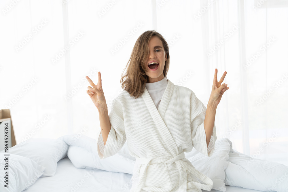 women smile happily and show up two fingers after waking up. Get a good night's sleep and start a new bright day. women smile happily and show up two fingers after waking up. Get a good night's sleep and start a new bright day.