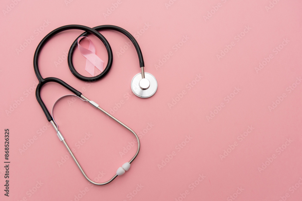 Breast cancer awareness. Pink ribbon sign with stethoscope on pink background with copy space Breast cancer awareness. Pink ribbon sign with stethoscope on pink background with copy space
