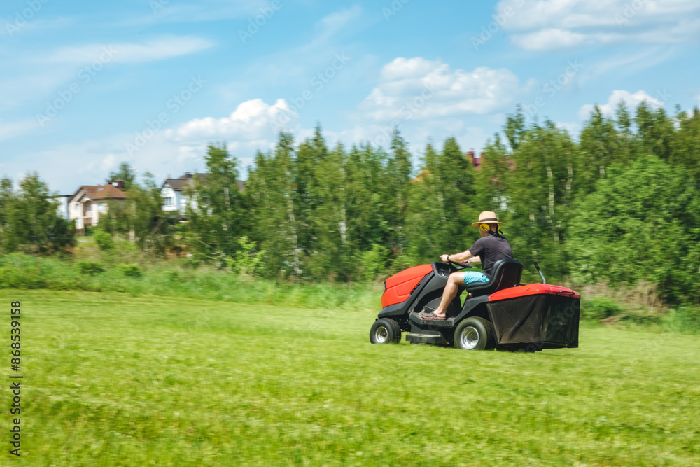 Man on lawn tractor mowing lawn on backyard. The red rider. The lawnmower tractor. High quality 4k footage Man on lawn tractor mowing lawn on backyard. The red rider. The lawnmower tractor. High quality 4k footage