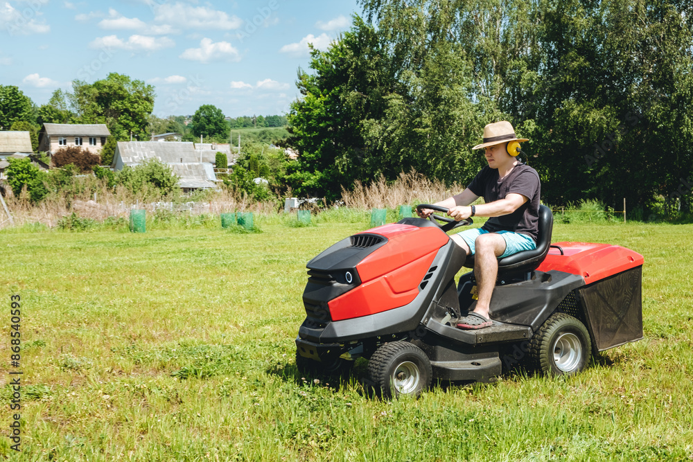 Man on lawn tractor mowing lawn on backyard. The red rider. The lawnmower tractor. High quality 4k footage Man on lawn tractor mowing lawn on backyard. The red rider. The lawnmower tractor. High quality 4k footage