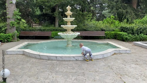 Nikita Botanical Garden in Crimea, one of the oldest botanical gardens in Europe. little boy at the fountain. photo