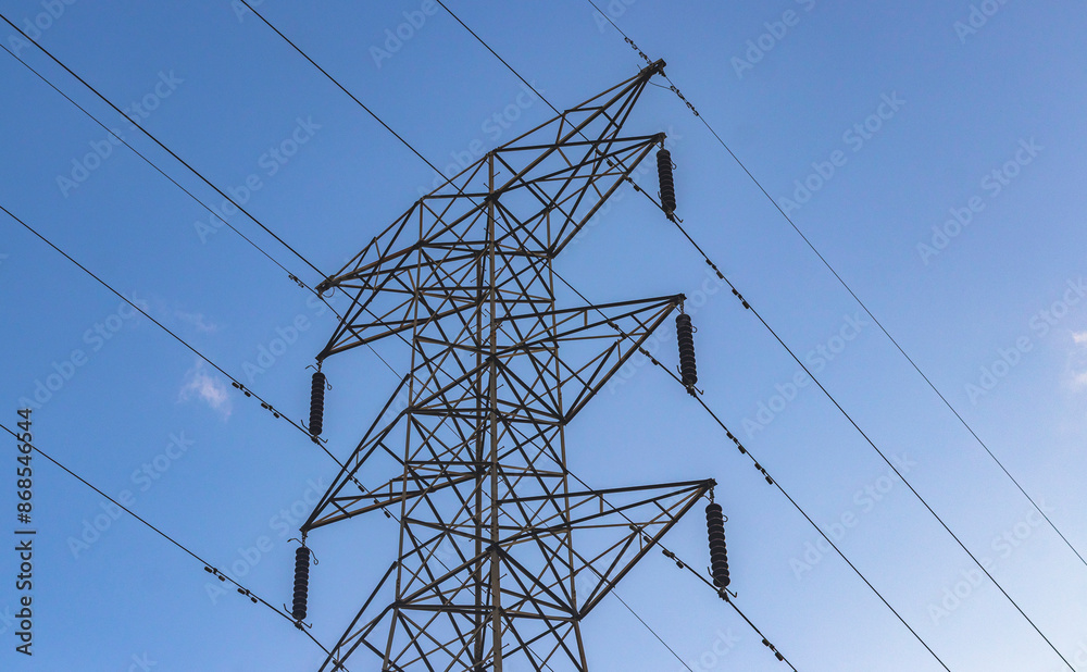 power lines with pylon, electrical tower in blue sky background 