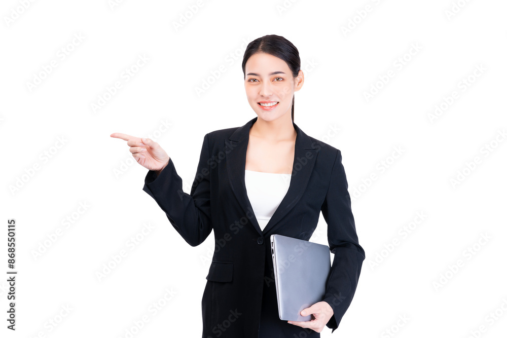 A professional woman in a black suit confidently points to the side while holding a laptop computer. Her poised stance and friendly expression highlight her competence and approachability. A professional woman in a black suit confidently points to the side while holding a laptop computer. Her poised stance and friendly expression highlight her competence and approachability.