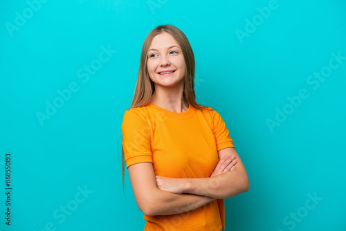 Young Russian woman isolated on blue background looking to the side and smiling © luismolinero