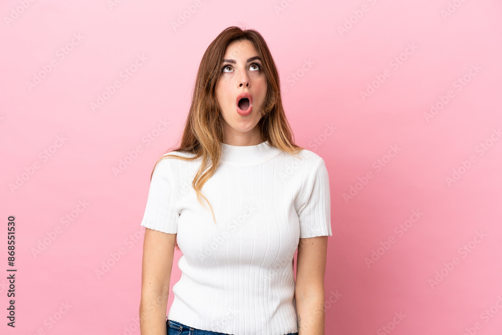Caucasian woman isolated on pink background looking up and with surprised expression Caucasian woman isolated on pink background looking up and with surprised expression