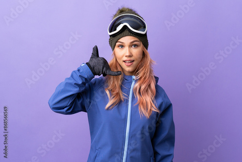 Skier teenager girl with snowboarding glasses over isolated purple background making phone gesture. Call me back sign