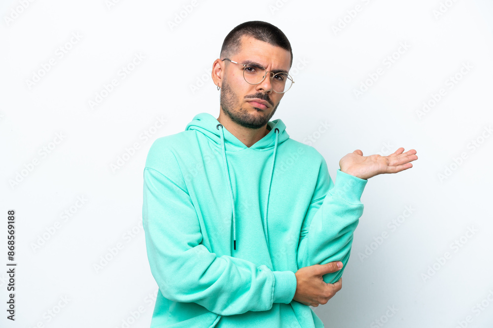 Young caucasian man isolated on white background having doubts Young caucasian man isolated on white background having doubts