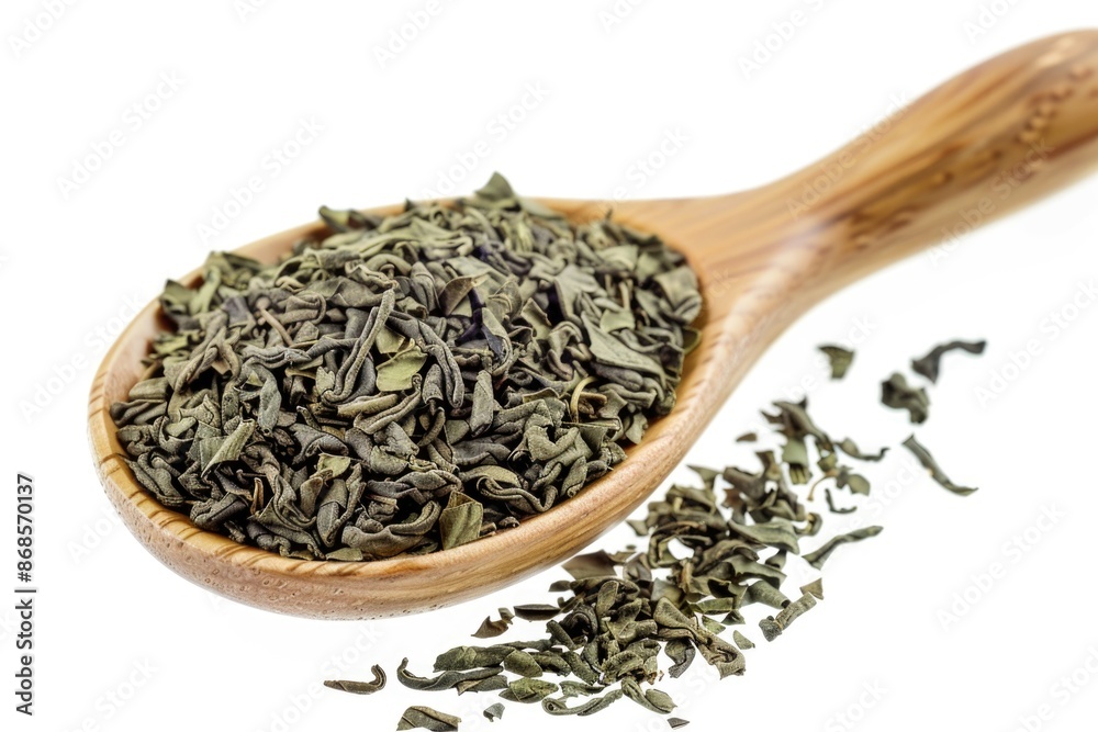Fototapeta premium A wooden spoon filled with green tea leaves for brewing and serving