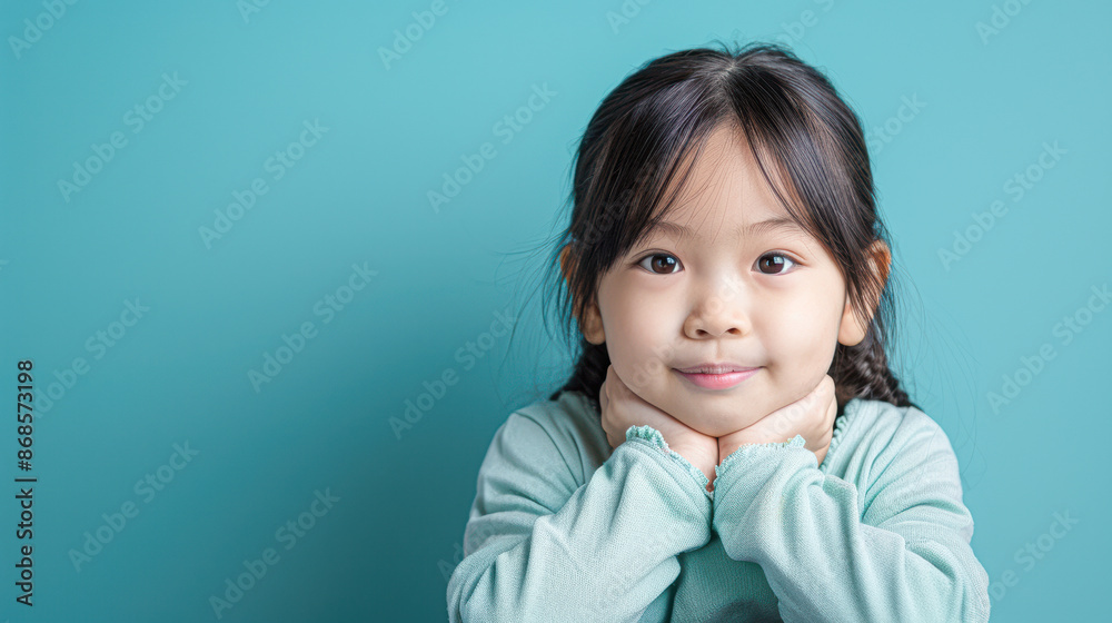 Radiant Asian Child Posing Against Vibrant Blue Background Radiant Asian Child Posing Against Vibrant Blue Background