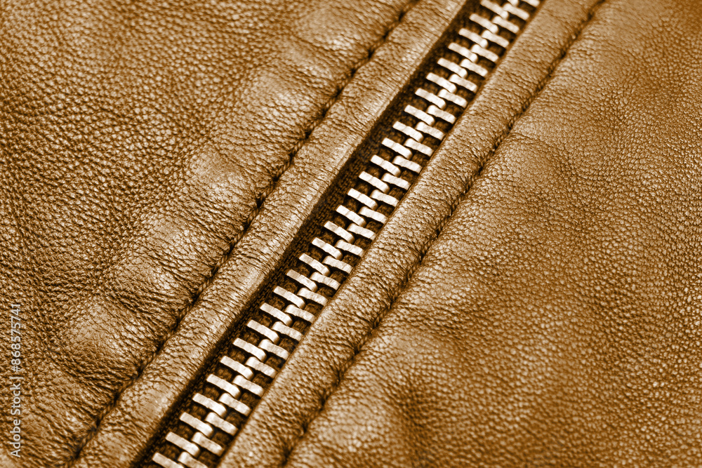 Obraz na plátně Macro shot of zipper on brown leather texture background with stitching