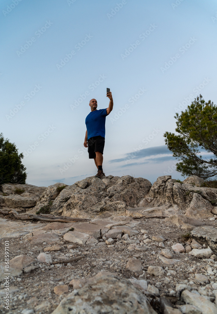One man standing on a rock taking selfies with the phone. One man standing on a rock taking selfies with the phone.