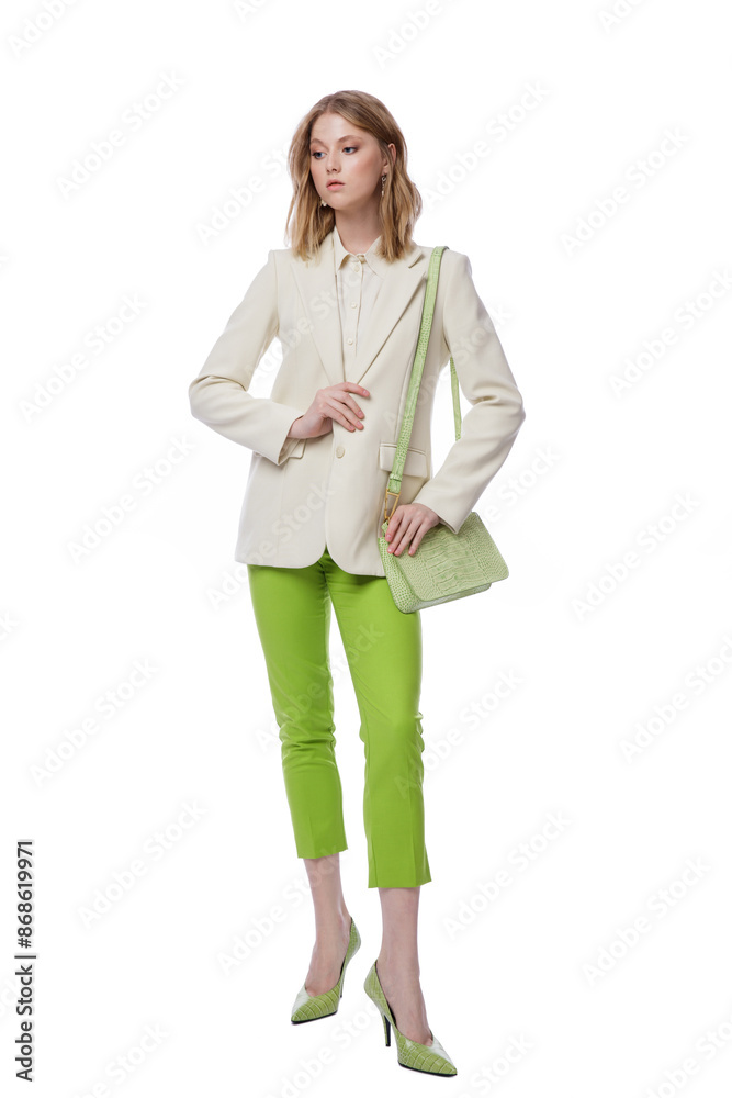High fashion photo of a beautiful elegant young woman in pretty green pants, trousers, jacket, handbag posing on white background. Slim figure. Blonde High fashion photo of a beautiful elegant young woman in pretty green pants, trousers, jacket, handbag posing on white background. Slim figure. Blonde
