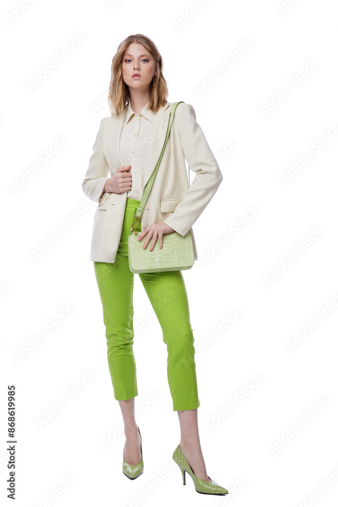 High fashion photo of a beautiful elegant young woman in pretty green pants, trousers, jacket, handbag posing on white background. Slim figure. Blonde High fashion photo of a beautiful elegant young woman in pretty green pants, trousers, jacket, handbag posing on white background. Slim figure. Blonde