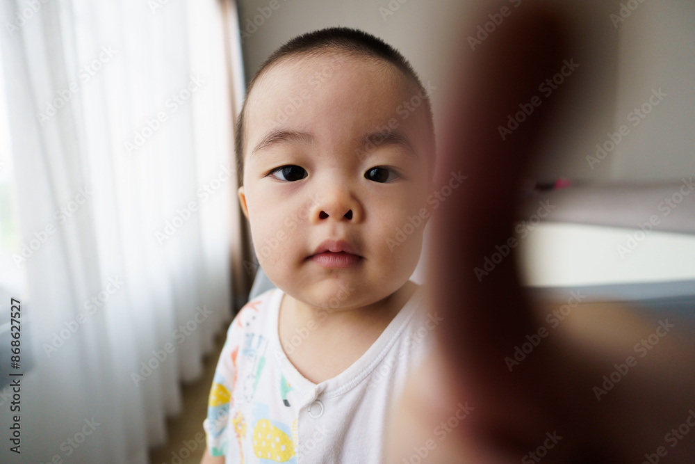 Asian little boy pointing finger in front of lens with defocus middle frame Asian little boy pointing finger in front of lens with defocus middle frame