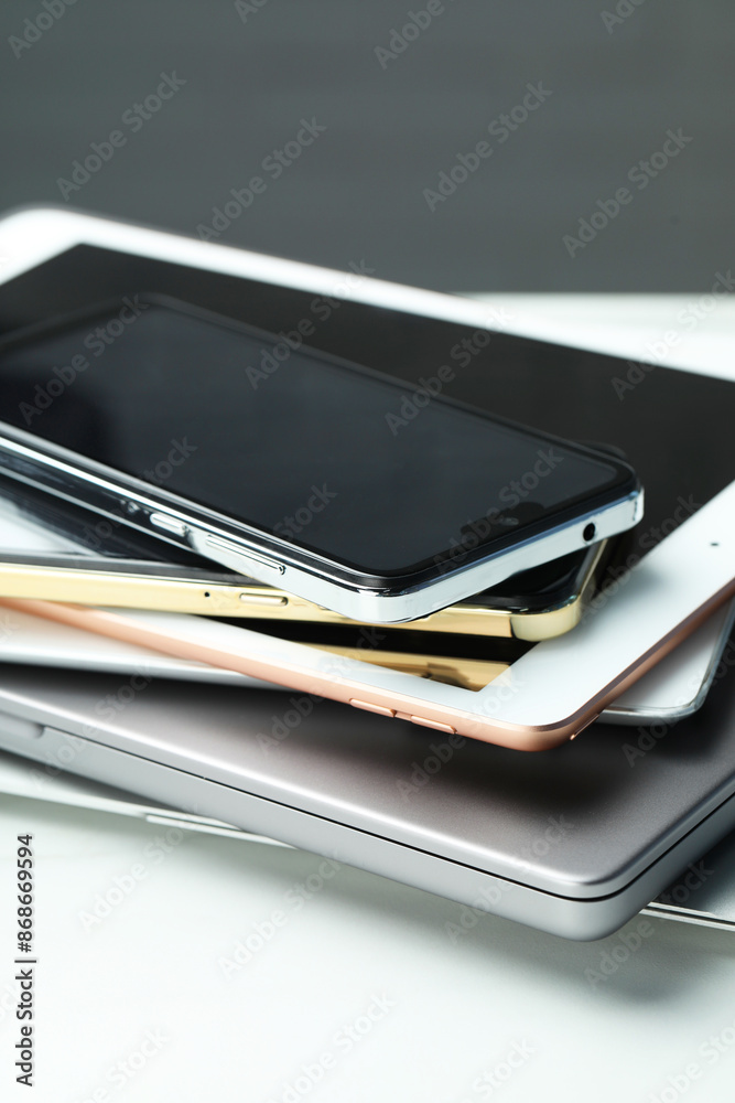 Stack of electronic devices on white table, closeup Stack of electronic devices on white table, closeup