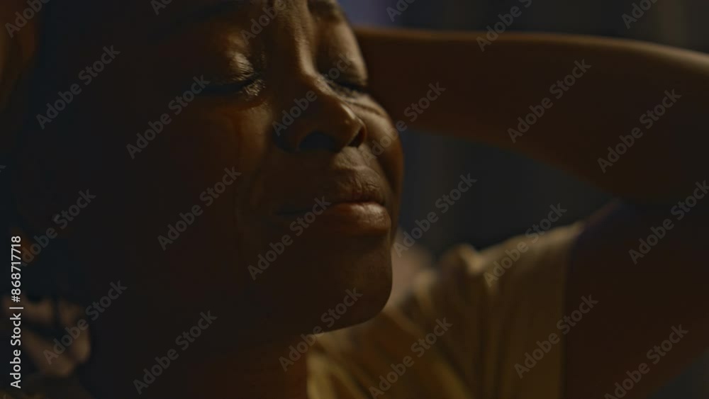 Closeup of young Black woman crying at night while experiencing traumatic memories about sexual assault, being victim of violence