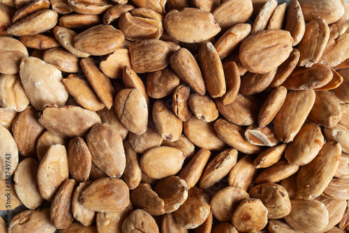 Close-up of homemade toasted blanched almonds showcasing their detailed rich, nutty texture and warm tones of these premium nuts. Natural food.