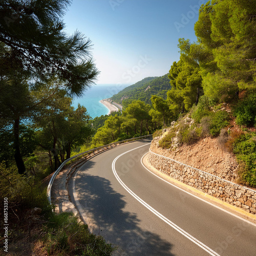 A mountain road surrounded by trees on a hot, sunny day curves around a mountain with the beach visible in the distance.