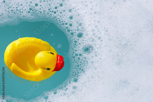 Fotografie Yellow rubber duck in water with soap foam
