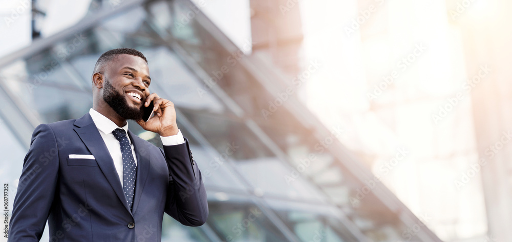 Happy African Entrepreneur Talking On Mobile Phone Standing In Urban Area In City. Business Communication Strategies Concept. Empty Space