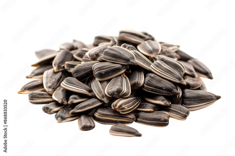 A pile of sunflower seeds on a white surface, great for food or decoration A pile of sunflower seeds on a white surface, great for food or decoration
