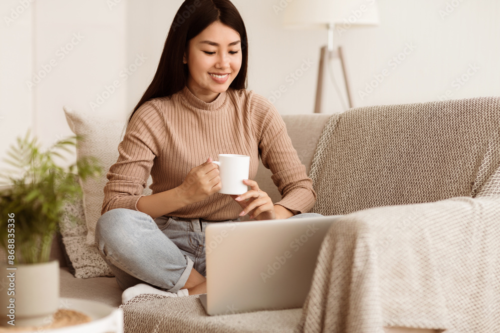 Happy Girl Relaxing on Comfortable Couch and Using Laptop at Home, Surfing Internet Happy Girl Relaxing on Comfortable Couch and Using Laptop at Home, Surfing Internet
