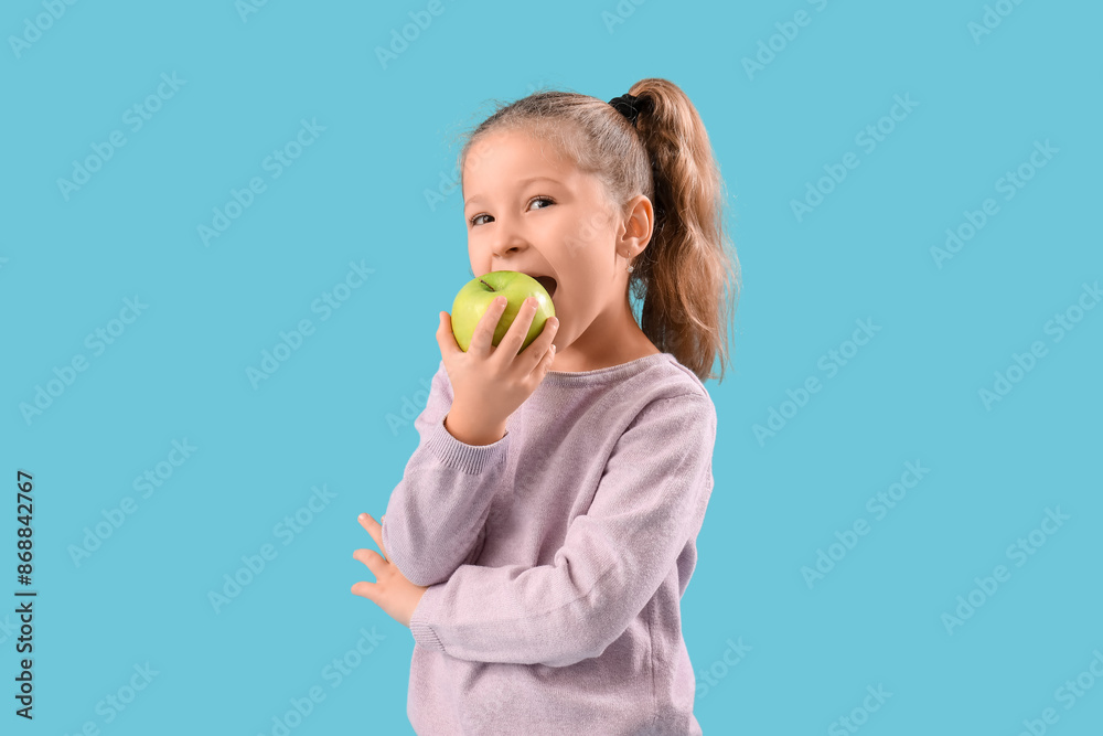 Cute little girl eating apple on blue background. Rosh Hashanah (Jewish New Year) celebration Cute little girl eating apple on blue background. Rosh Hashanah (Jewish New Year) celebration