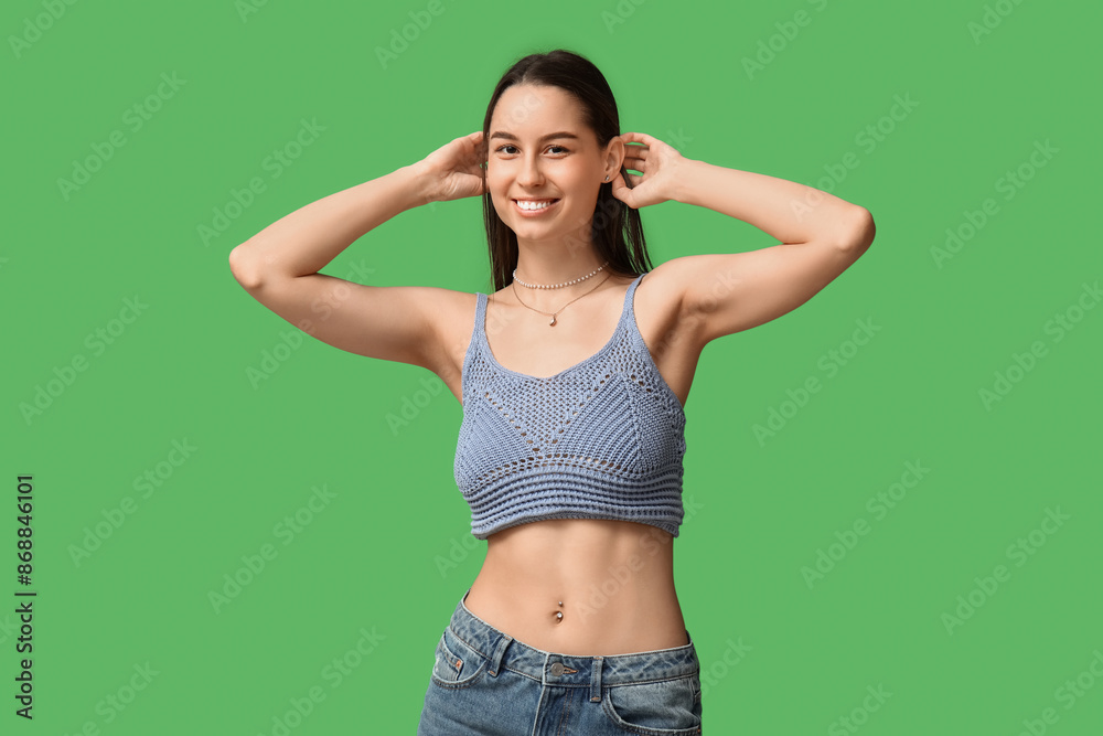 Beautiful young happy woman with piercing navel on green background Beautiful young happy woman with piercing navel on green background