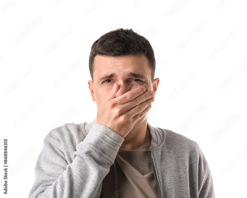 Handsome young man feeling bad smell on white background
