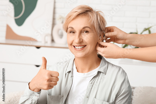 Young woman putting hearing...