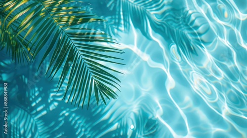 The image features pristine turquoise pool water reflecting palm leaves, evoking feelings of relaxation and tropical serenity. The reflections create soothing light patterns. © Design Depot