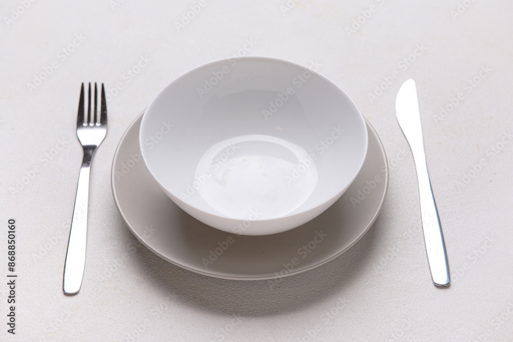 Table setting with clean plates and cutlery on white background Table setting with clean plates and cutlery on white background