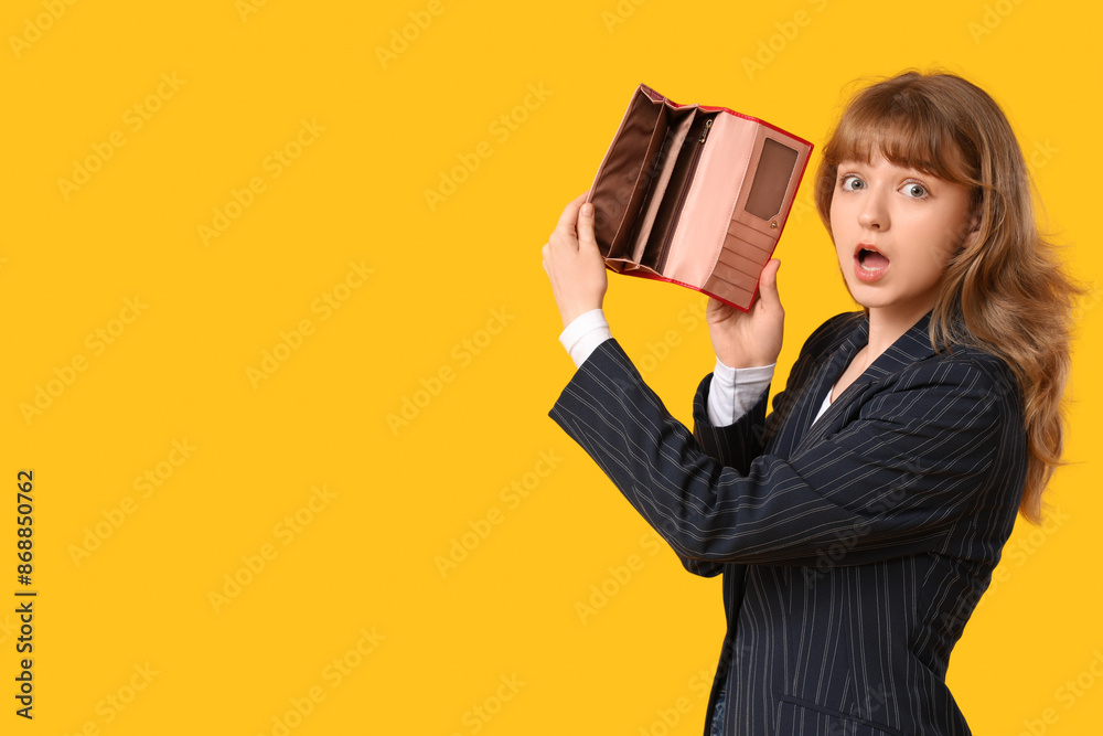Surprised young woman holding empty wallet on yellow background Surprised young woman holding empty wallet on yellow background