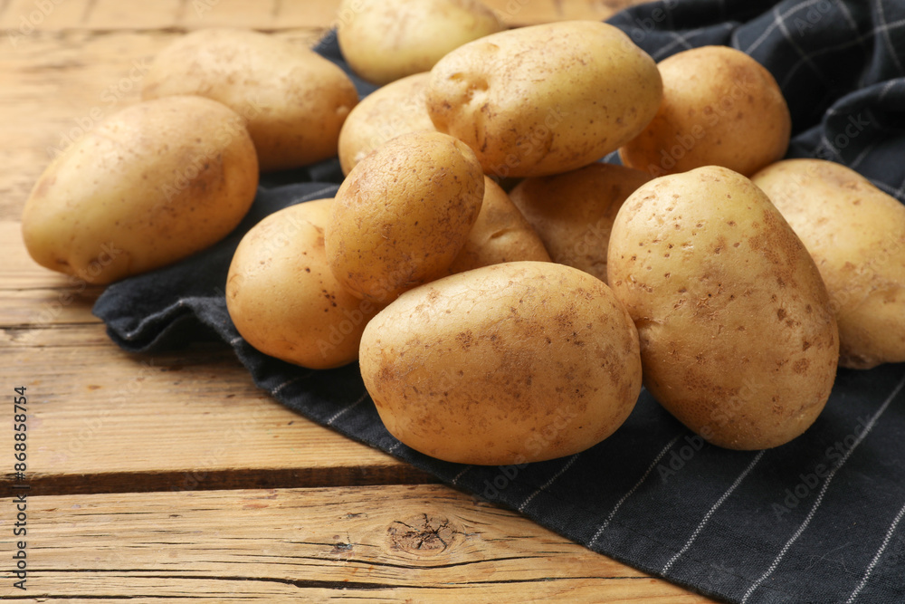 Many fresh potatoes on wooden table, closeup