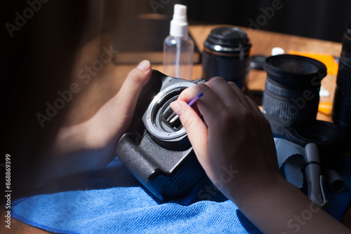Photograph of unrecognizable person cleaning a camera sensor.
