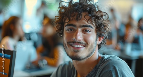 Smiling Young Man Working on a Computer in a Modern Office