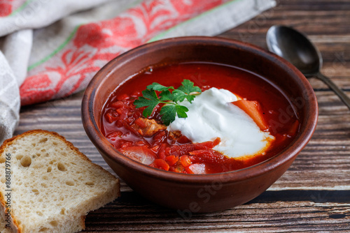 Traditional Ukrainian Russian borscht . Bowl of red beet root soup borsch with white cream with bread on wooden background. Beet Root delicious soup. Traditional Ukraine Russia food cuisine photo