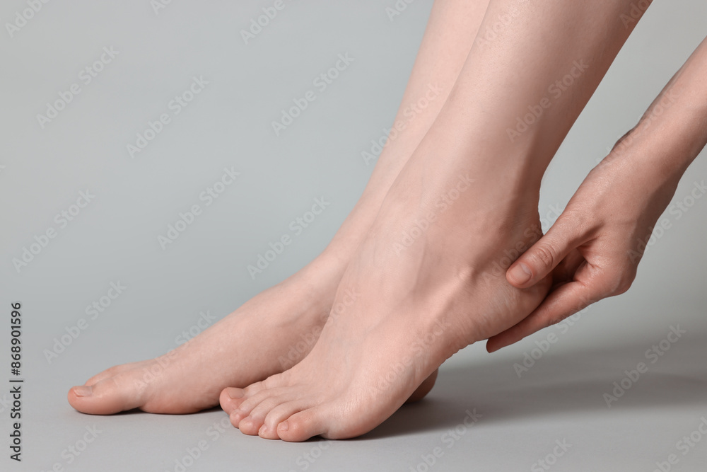 Closeup view of woman`s groomed feet after care procedure on grey background Closeup view of woman`s groomed feet after care procedure on grey background