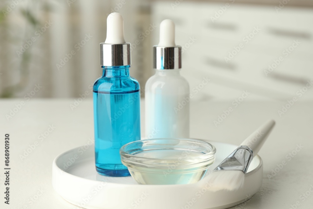 Peeling procedure. Bottles of chemical peel, bowl with liquid and brush on white table indoors Peeling procedure. Bottles of chemical peel, bowl with liquid and brush on white table indoors
