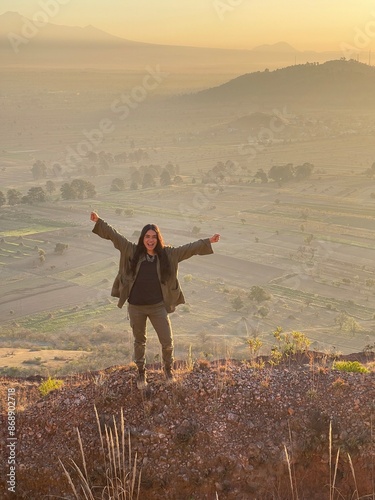 Young Mexican Girl with triumph pose in the top of a mountain in San Jerónimo Tecuanipan, Puebla, Mexico