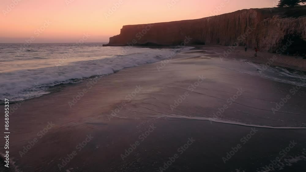 Rocky cliffs, sandy beach and ocean surf at sunset. Davenport Beach, Santa Cruz, California, United States of America. Rocky cliffs, sandy beach and ocean surf at sunset. Davenport Beach, Santa Cruz, California, United States of America.