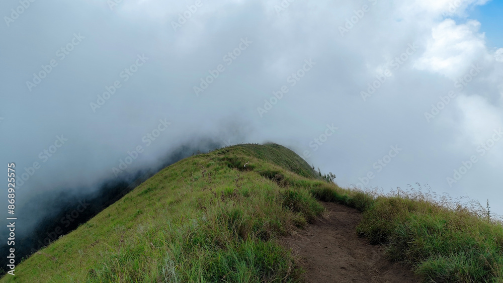 green hill, view of Anak Dara hill when the fog, around Mount Rinjani, Sembalun Lombok, Indonesia. the landscape is for hiking and outdoor lifestyle concept. beautiful natural scenery green hill, view of Anak Dara hill when the fog, around Mount Rinjani, Sembalun Lombok, Indonesia. the landscape is for hiking and outdoor lifestyle concept. beautiful natural scenery