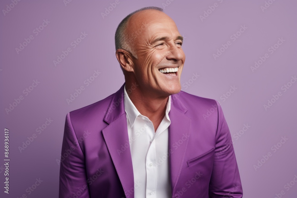 Handsome senior man laughing and looking at camera while standing against purple background Handsome senior man laughing and looking at camera while standing against purple background