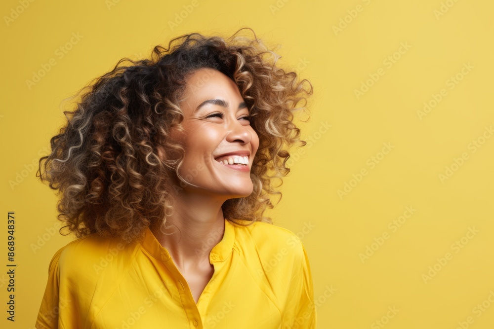 Portrait of happy african american woman with curly hair on yellow background Portrait of happy african american woman with curly hair on yellow background
