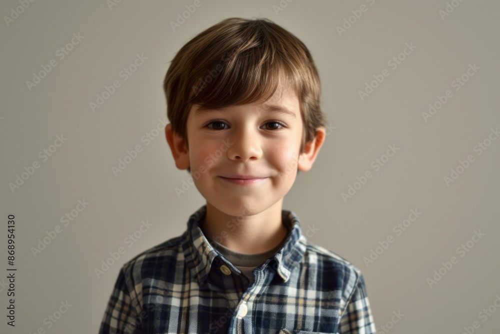 Portrait of a cute little boy in checkered shirt on grey background Portrait of a cute little boy in checkered shirt on grey background
