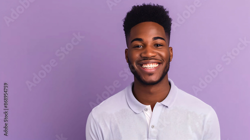 A smiling millennial man in a polo shirt, looking confidently at the camera against a solid purple background