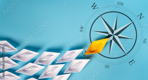 Yellow Paper Boat On Compass Leading A Fleet Of Small White Boats.