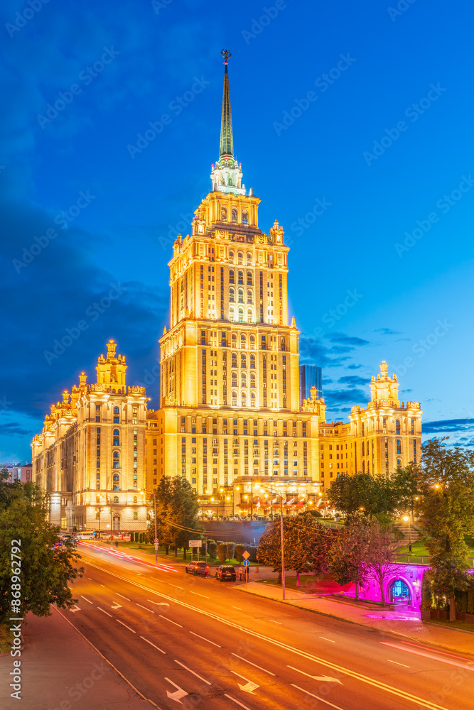 Illuminated high-rise stalinist building near river at summer night in Moscow, Russia. Historic name is Hotel Ukraina. Illuminated high-rise stalinist building near river at summer night in Moscow, Russia. Historic name is Hotel Ukraina.
